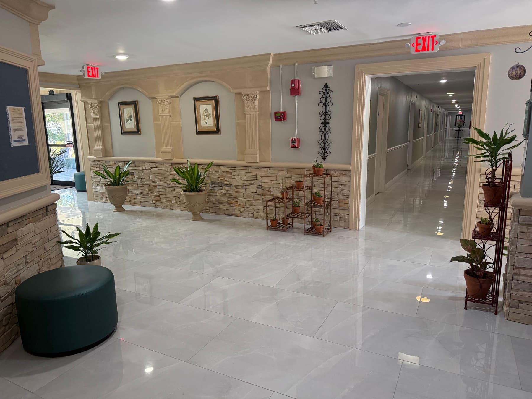 Bright common area with stone accent walls, arched alcoves and plants