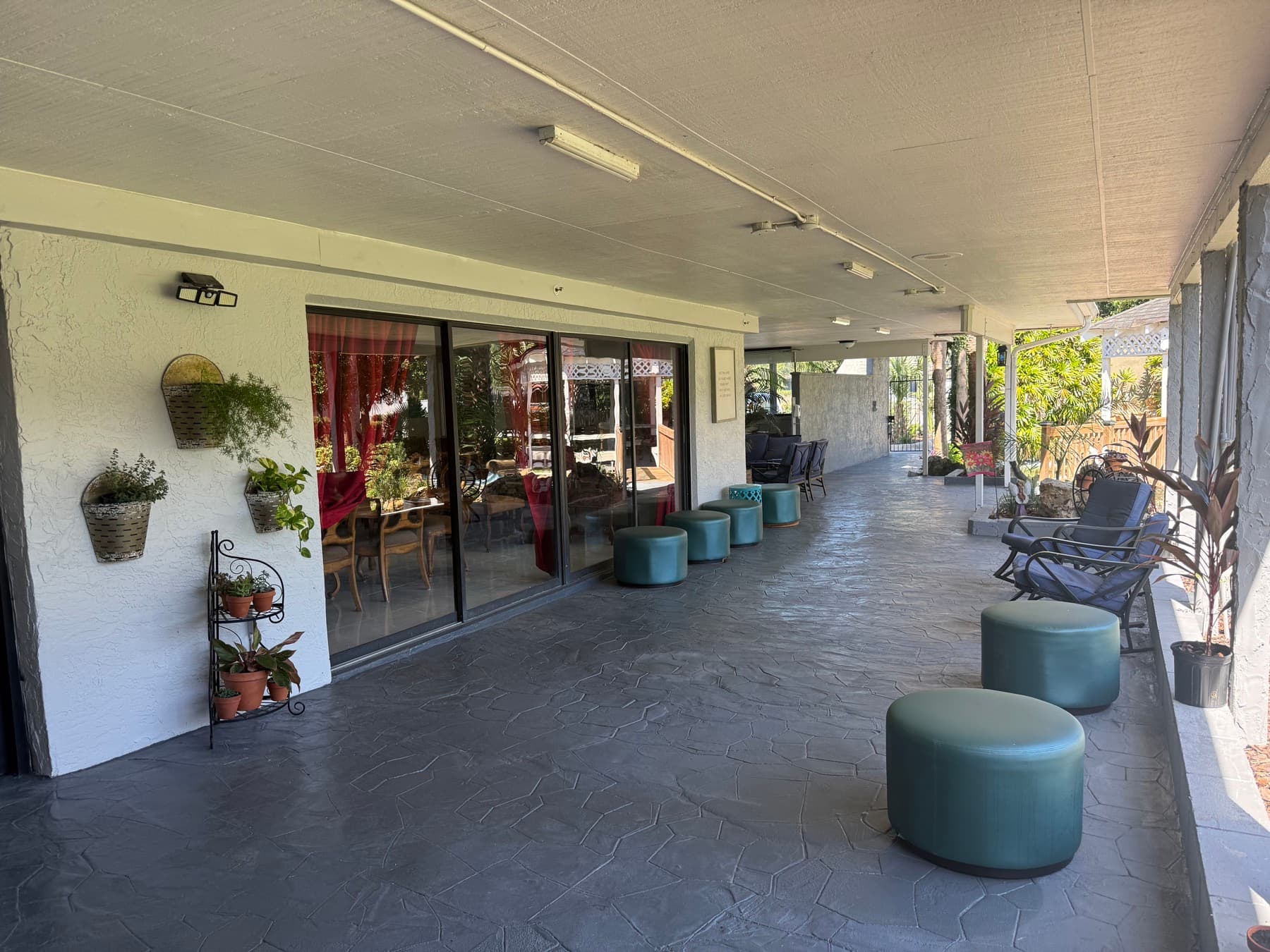 Covered patio with seating, plants and doors to the dining room