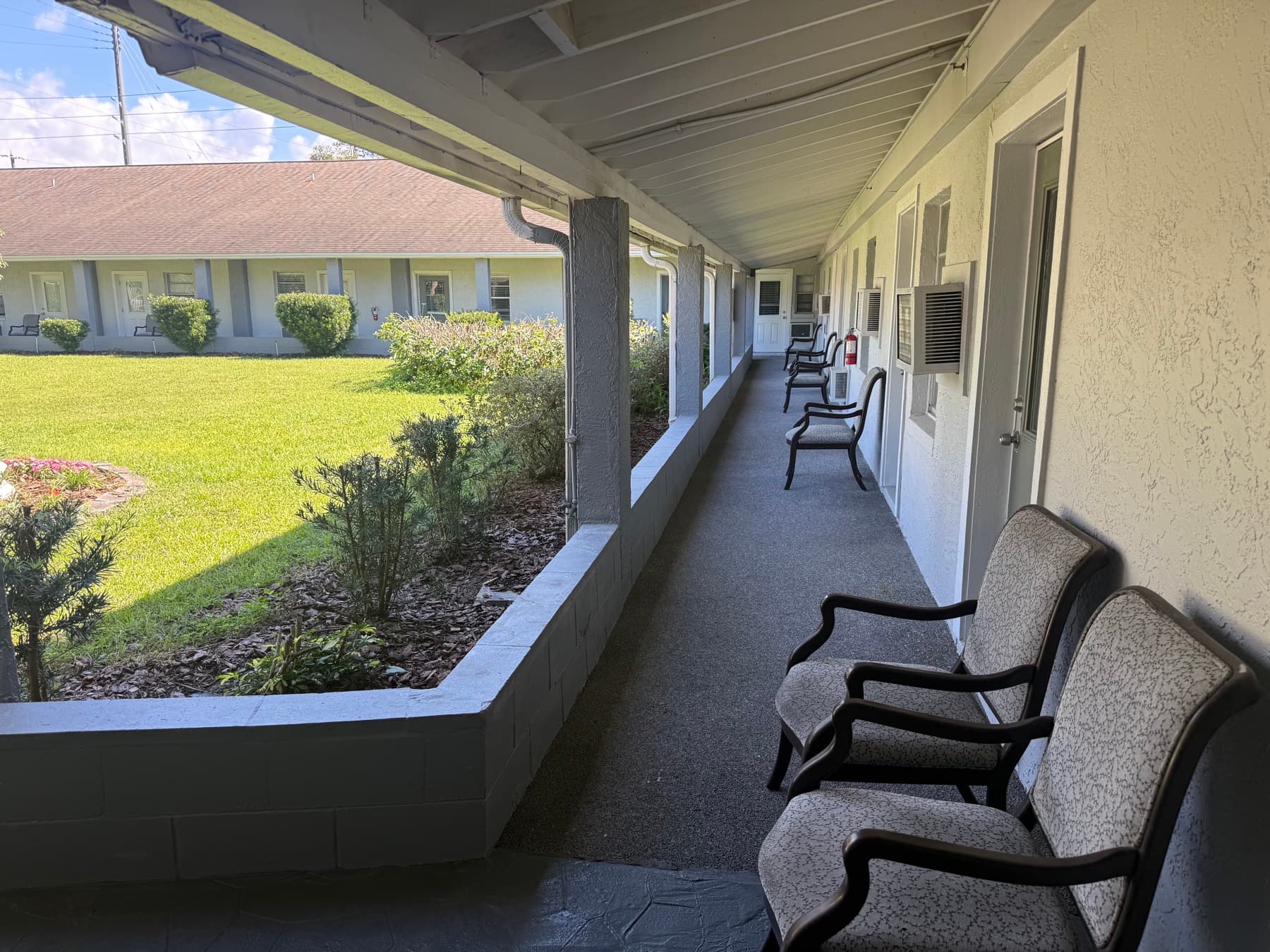 Covered walkway with chairs overlooking the garden courtyard